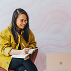 Woman writing and using website