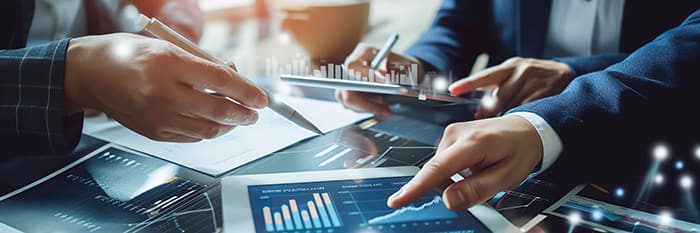 Three federal employees collaborating while analyzing data analytics on a computer screen, highlighting federal agencies' commitment to enhancing customer experience (CX) in 2025 through data, AI, and digital engagement.