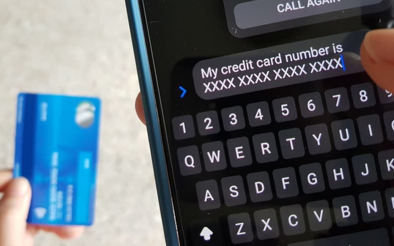 Person typing a credit card number into a phone message — example of a toll scam risk.