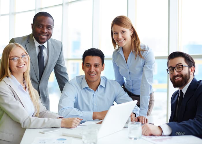 Smiling government workers meeting around a computer
