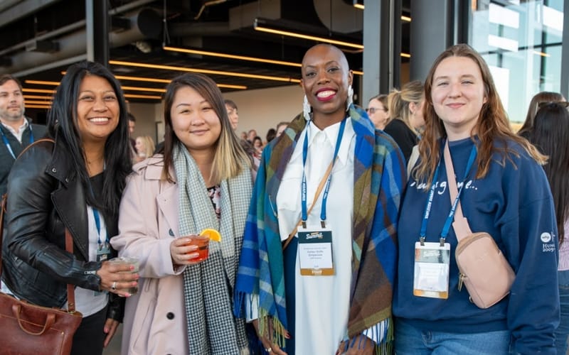 Women standing an posing for a picture at a travel and tourism conference.