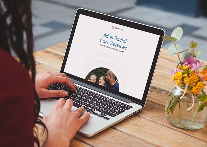 A person with their laptop open to the Adult Social Care toolkit.