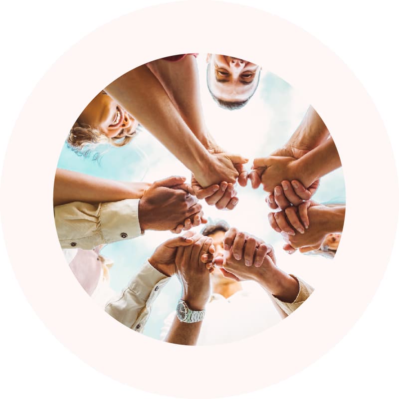A diverse group of people holding hands, symbolizing collective community improvement through the Granicus Government Experience Insight Foundations program.