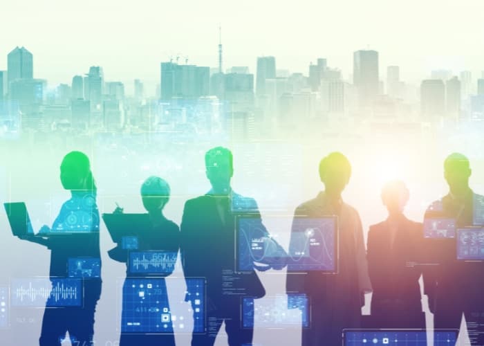 A group of silhouetted professionals standing before a city skyline, overlaid with digital technology and data graphics.