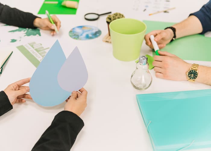 People working together at a table with eco-friendly materials.
