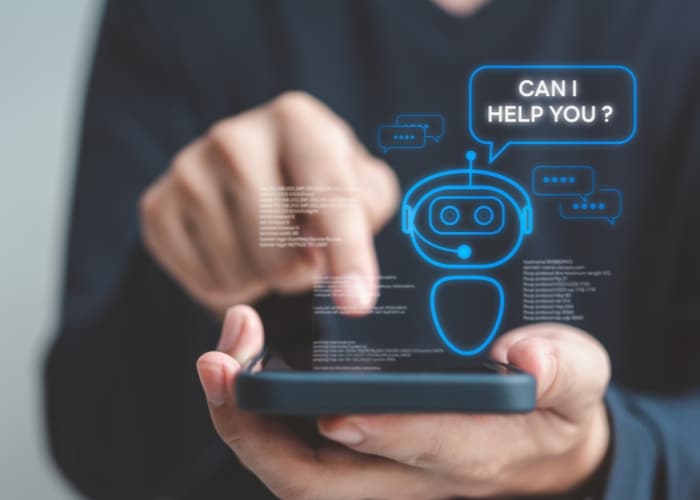A person interacts with a smartphone displaying a holographic chatbot asking, 'Can I help you?'